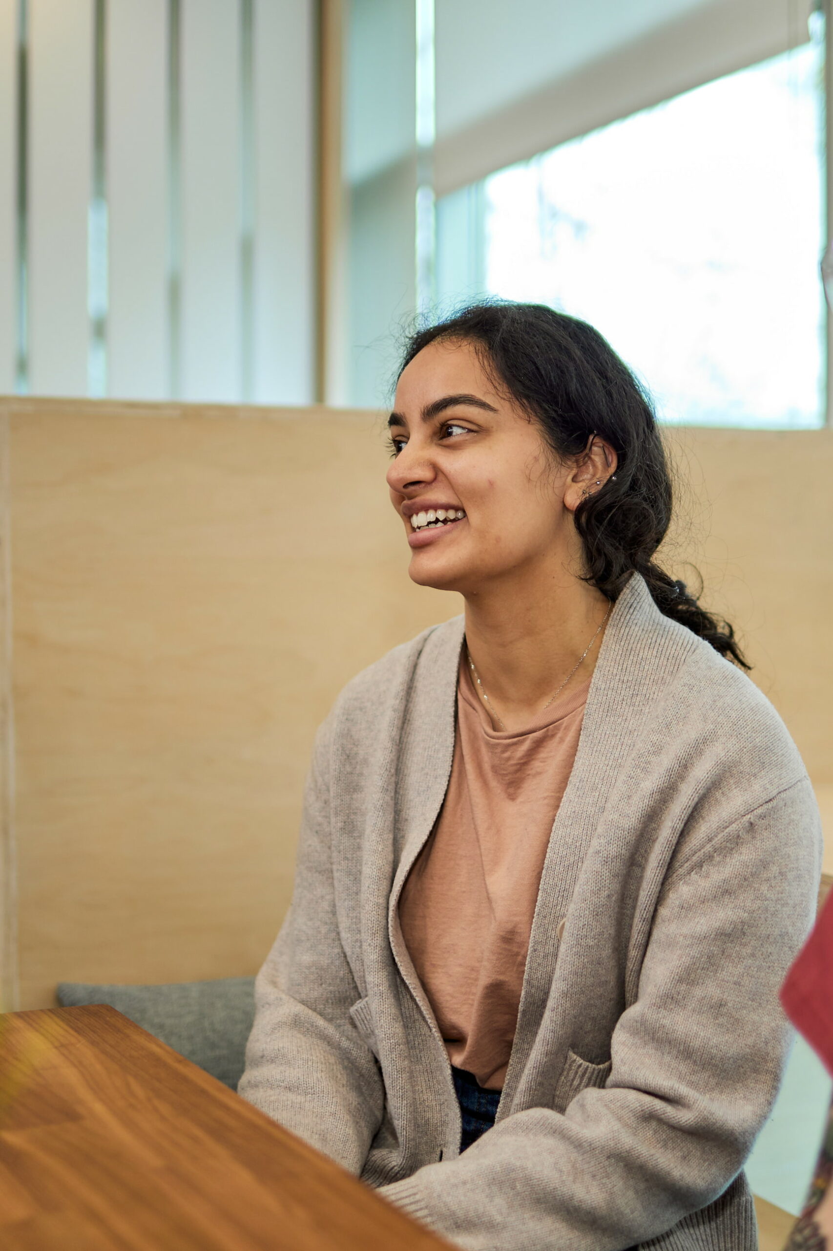 team member sitting at a table smiling